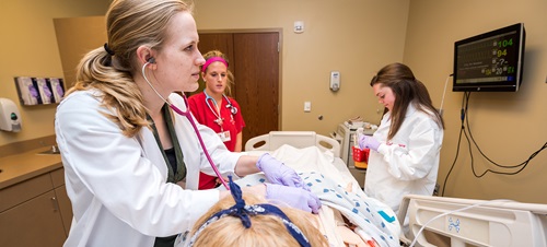 Three student in medical lab using stethoscope in training.