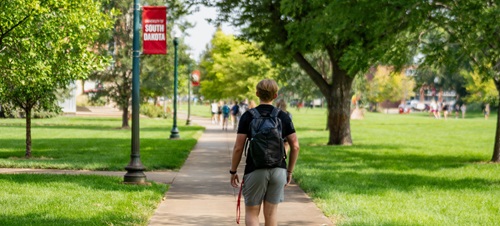 A student walking on the main campus towards his classroom.