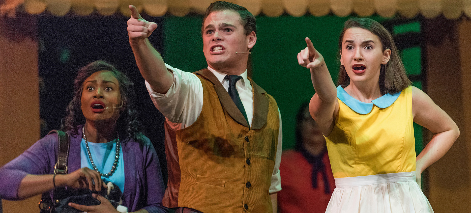 3 theatre students pointing during an on-stage production.