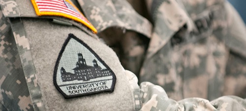 A close up of a military uniform with a USD patch on the left arm.