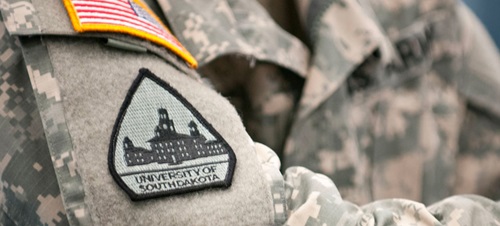 A close up of a military uniform with a USD patch on the left arm.