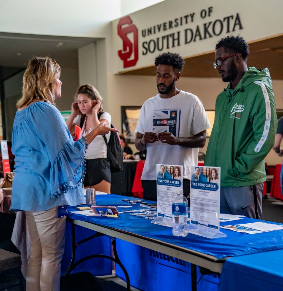Employer Speaking With Students at Tabling Event in Muenster University Center.