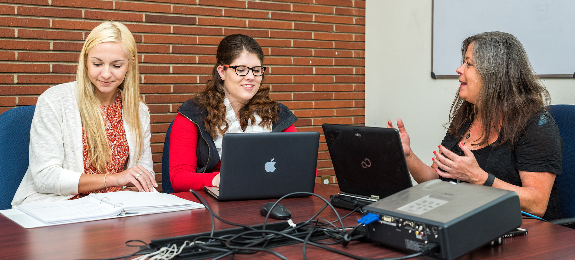 A student and faculty member working on laptops.