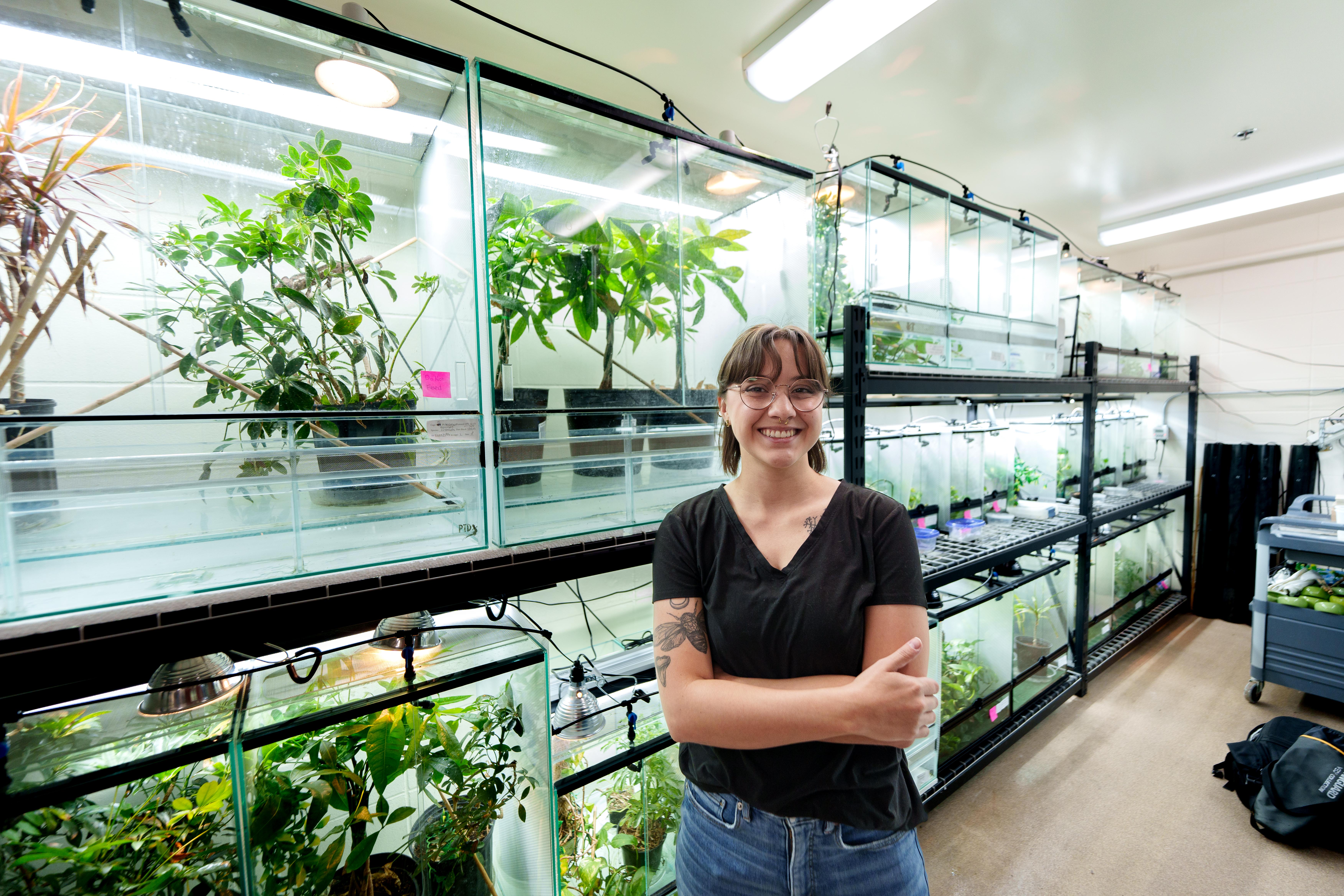 a person standing with their arms crossed in front of a botanical lab