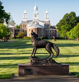 Legacy Statue With Old Main in the Background.