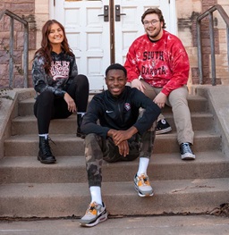 Students Sitting on Steps Outside Smiling.