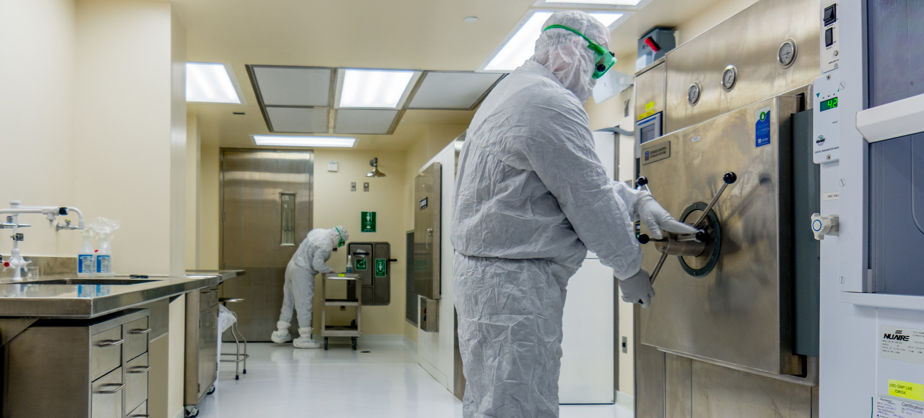 Workers in protective wear in lab.
