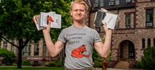 Carson Sehr outside holding Vermillion Literary Project books