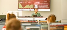 A teacher instructing class in the Ellis Finance lab.
