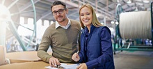 Two people smiling in a business setting.