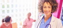 A doctor smiling in front of her patients.