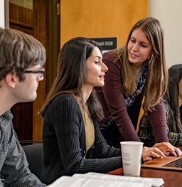 Teacher talks with students in classroom.
