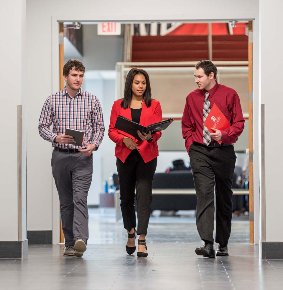 Three students walking down the hallway in the Sanford Sports Center.