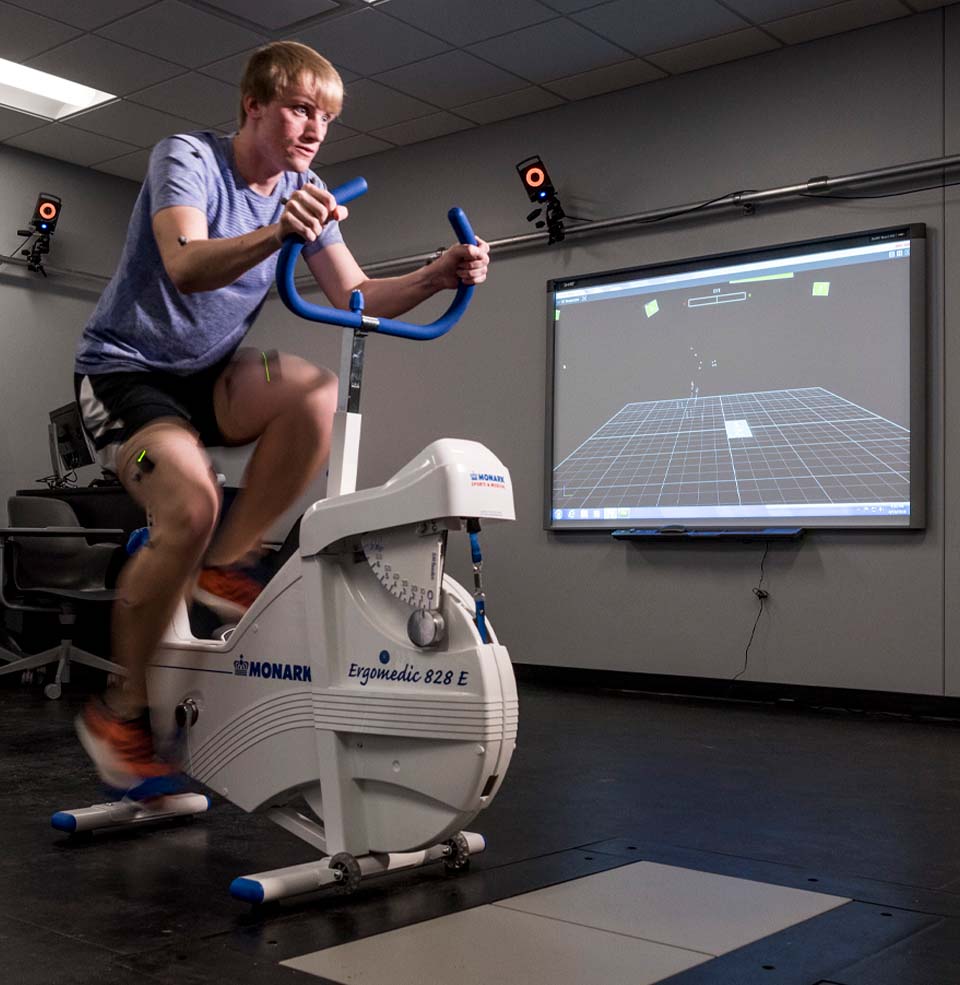 A student riding a bike while being analyzed by KSM equipment.