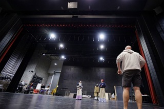 Actors and director practicing in a large room