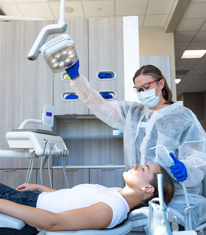 A dental hygiene student working on another.