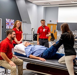 A group of health sciences people discussing around a patient