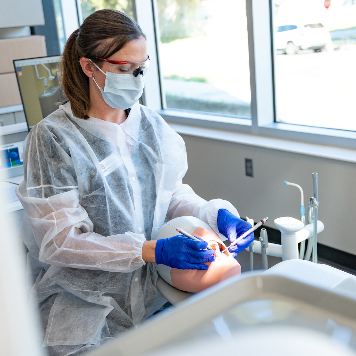 A dental hygienist cleaning her tools in the sink.