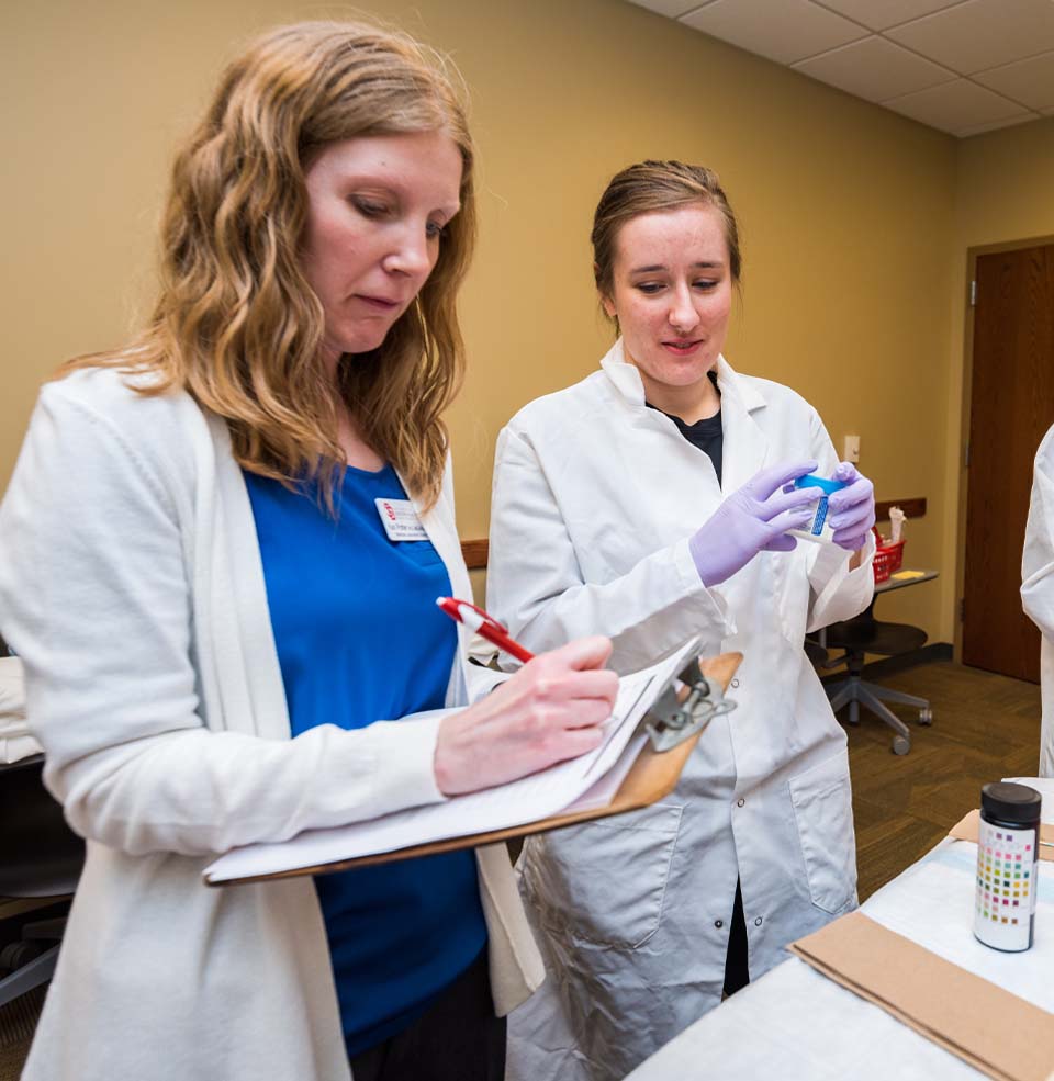 Student Providing Lab Results to Professor to Write Down.