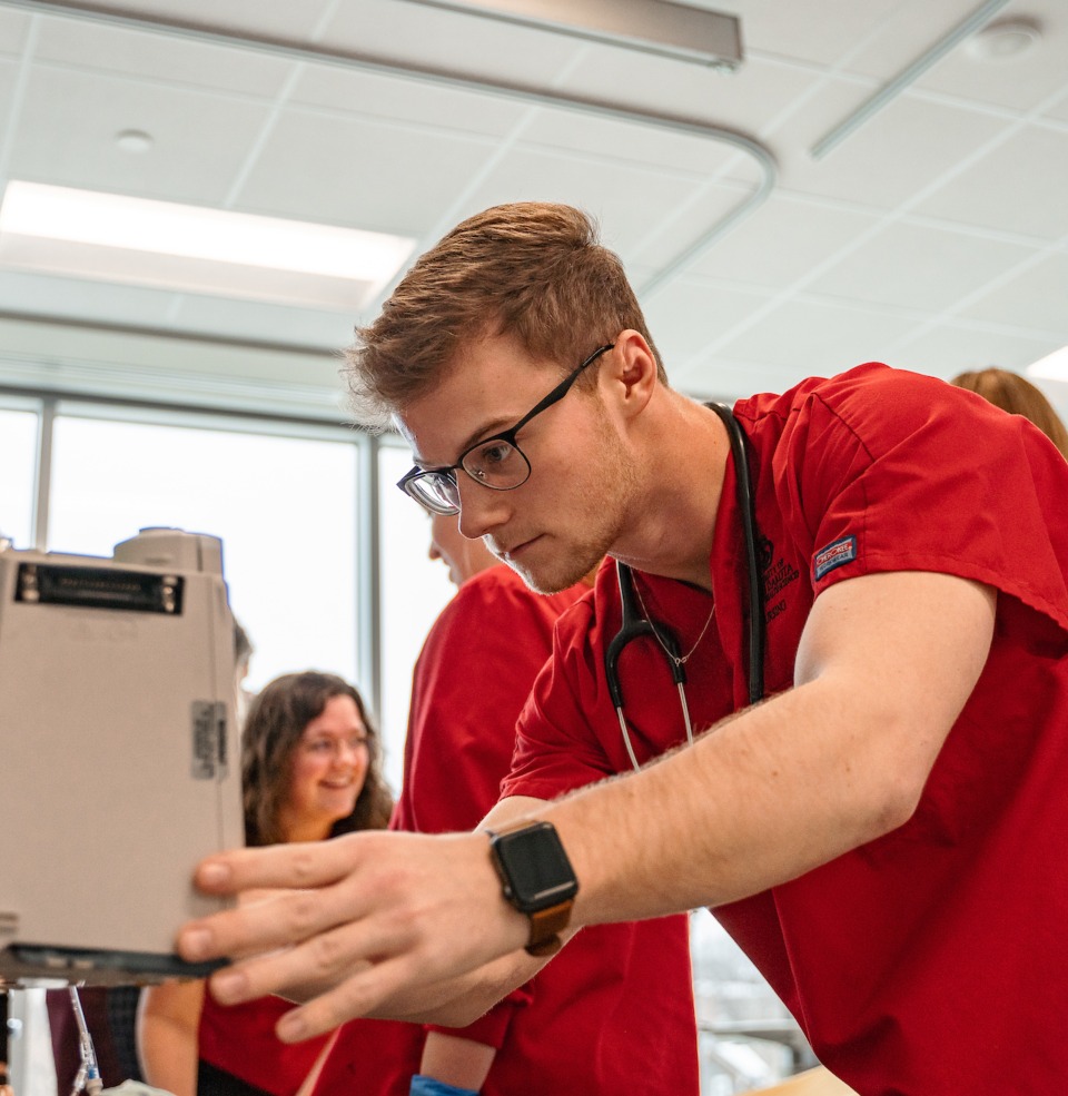 USD nursing students conducting in lab research work with other classmates.