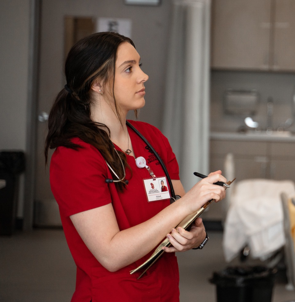 USD nursing students conducting in lab research work with other classmates.