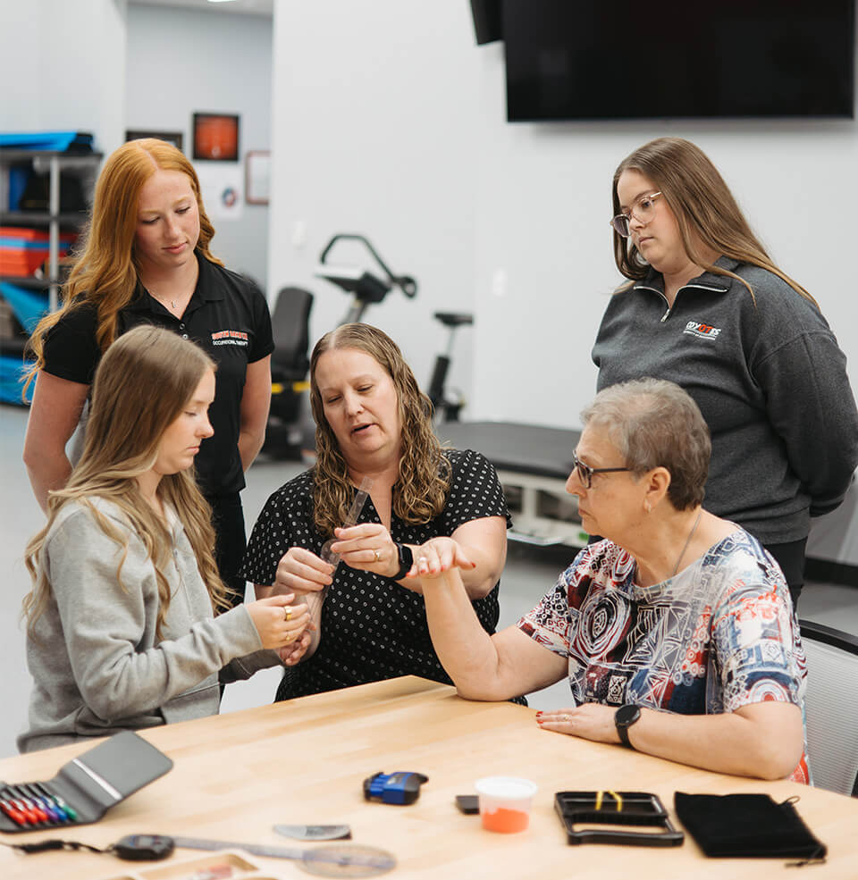 student working with teachers and classmates