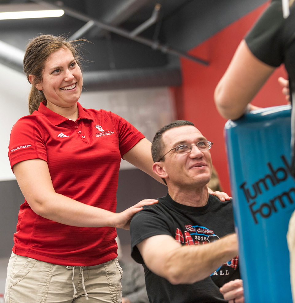 A person working with a USD student physical therapist.