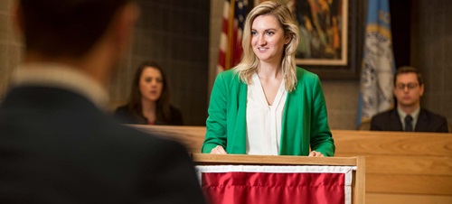 Female Law Student in Green Blazer at Lectern.