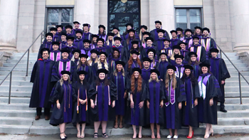 Knudson graduates standing on Art & Sciences stairs