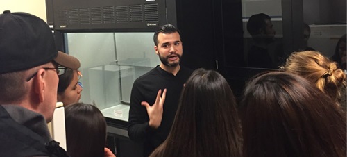 A graduate research student presenting in a lab.