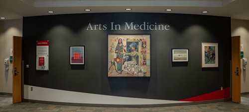 Student paintings hanging on the wall in the Parry Center's Arts in Medicine Gallery.