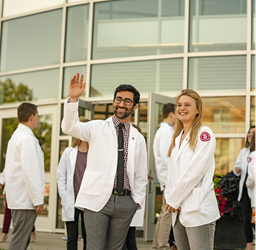 Male and Female med students outside waving