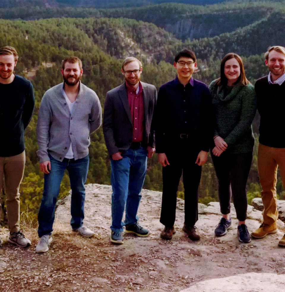 Rapid City faculty posing in front of mountains and hills.