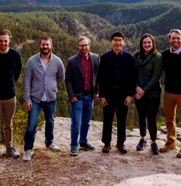 Rapid City faculty posing in front of mountains and hills.