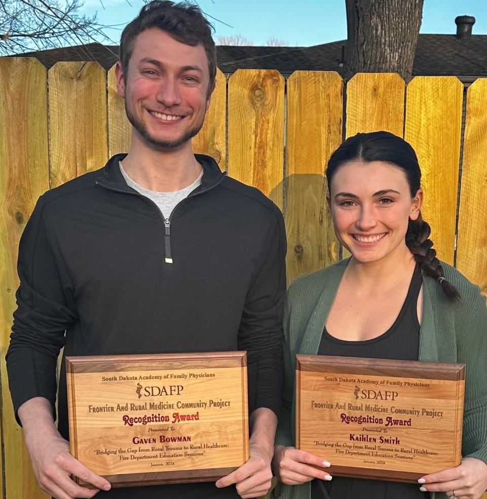 Gaven Kaihlen holding an award and smiling.