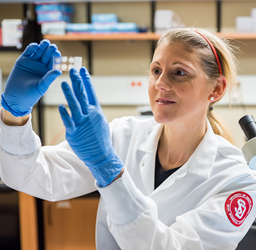 Female med student holding a microscope slide