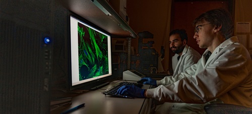 Students studying a screen in a dark lab.