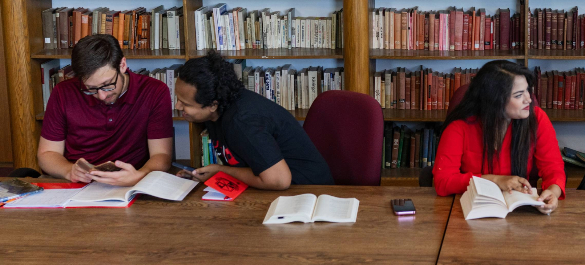 Three english students studying together in a classroom.