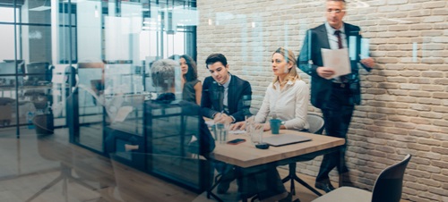 A business meeting in a glass room.