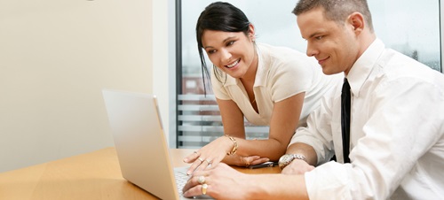 Two business students working a laptop.