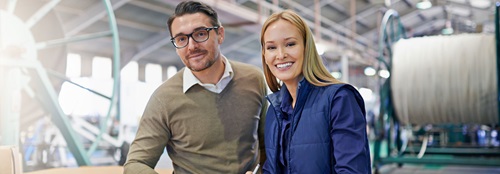 Two people smiling in a business setting.