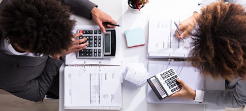 Two businesspeople calculating numbers as accountants.