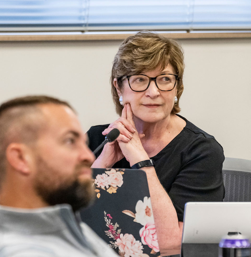 A teacher directing a lecture from their desk.