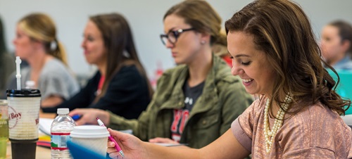 Students writing notes in a college class.