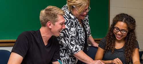 A teacher instructing two students.