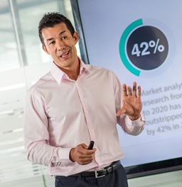 A man stand in front of a classroom giving a presentation