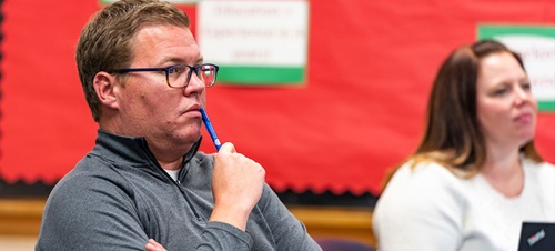Two students contemplating an idea in the classroom.