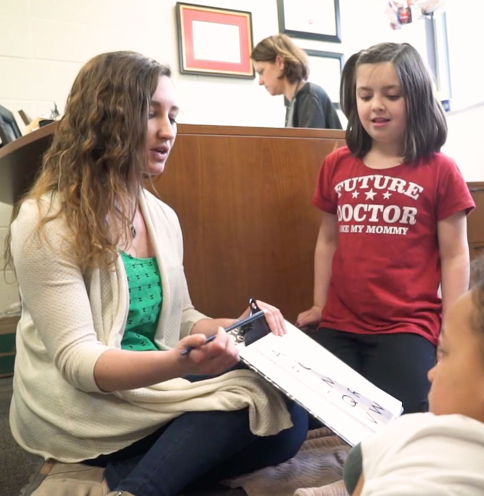 Elementary school teacher reads to students during class