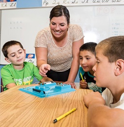 A woman teaching children in a classroom.