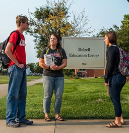 USD students gather outside the Dezell Education Building on campus in Vermillion